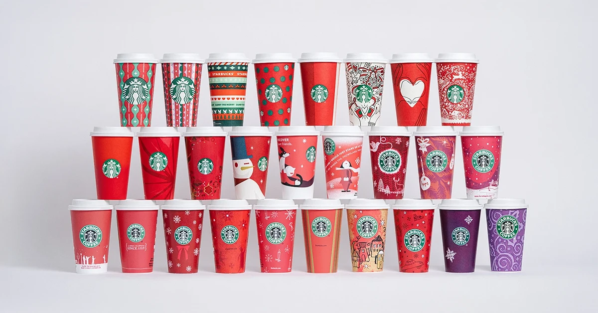 Festive Starbucks red holiday cup surrounded by holiday-themed decor, promoting the #RedCupContest—an engaging example of a last-minute marketing hack to drive customer interaction during the season.